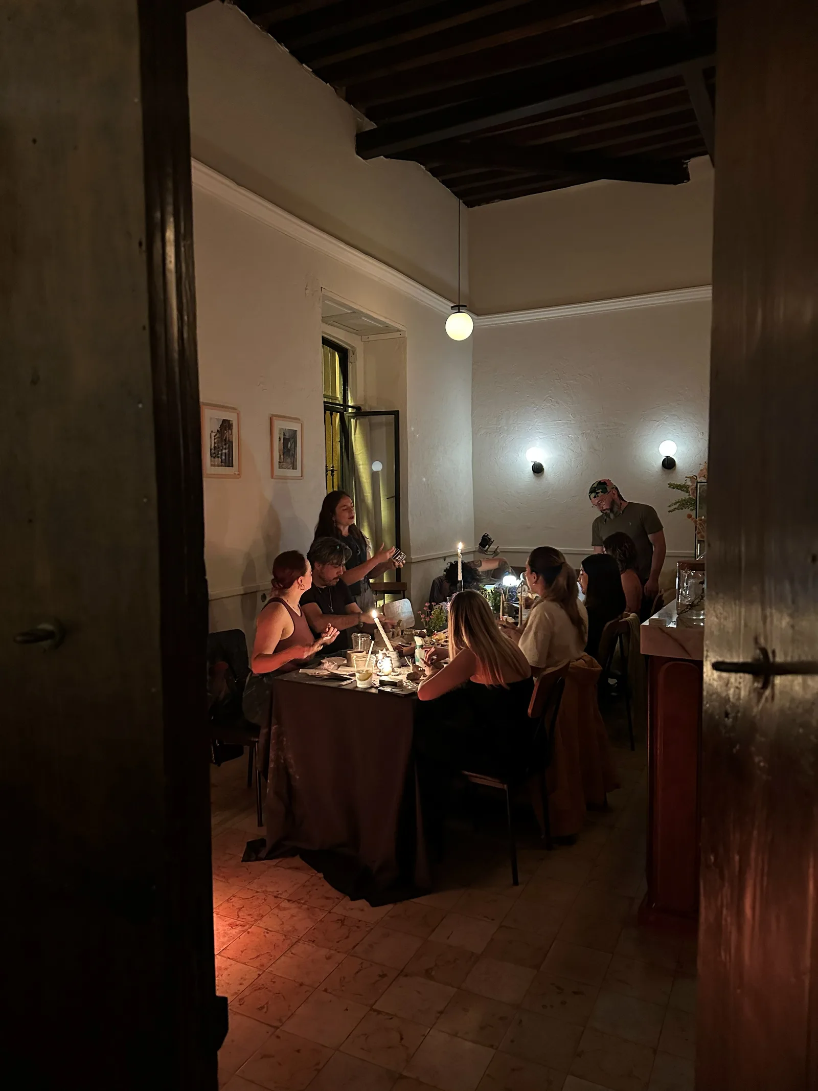 El café iluminado de noche, visto desde la calle durante el taller.