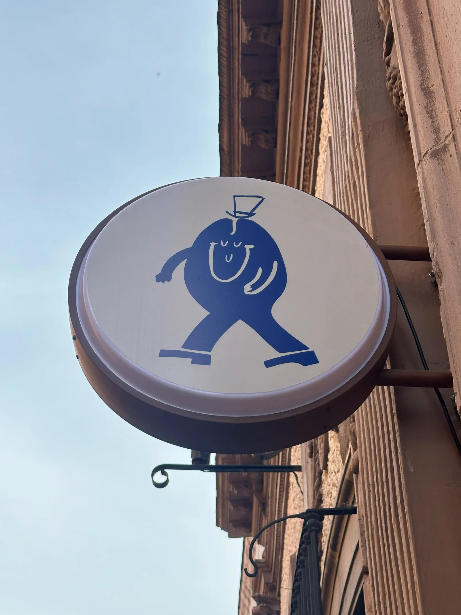 El letrero circular de Felicio con su personaje azul, visto desde la calle.